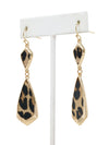 Leopard print earrings on a white stand with a white background