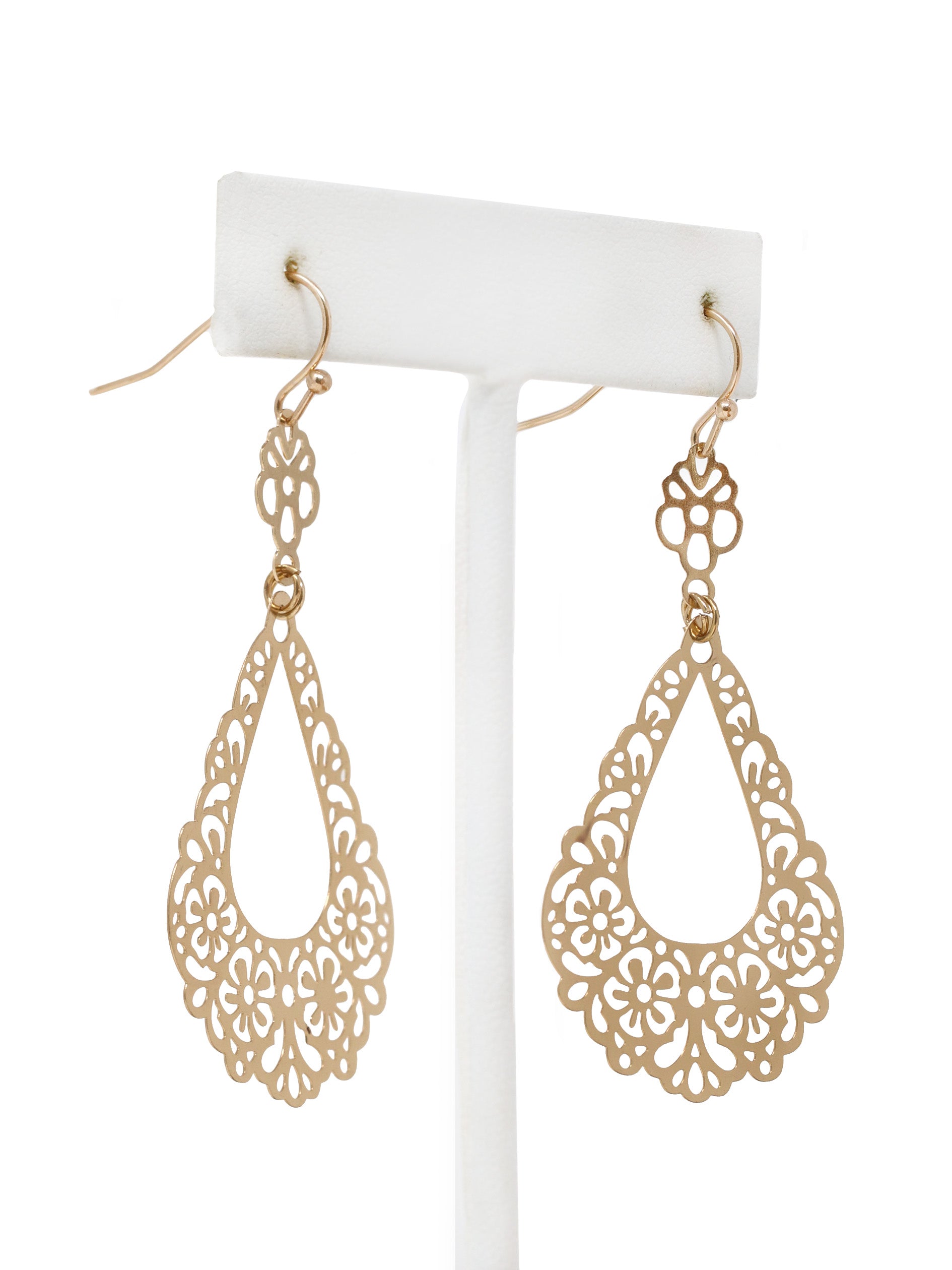 Gold filigree earrings on a white stand