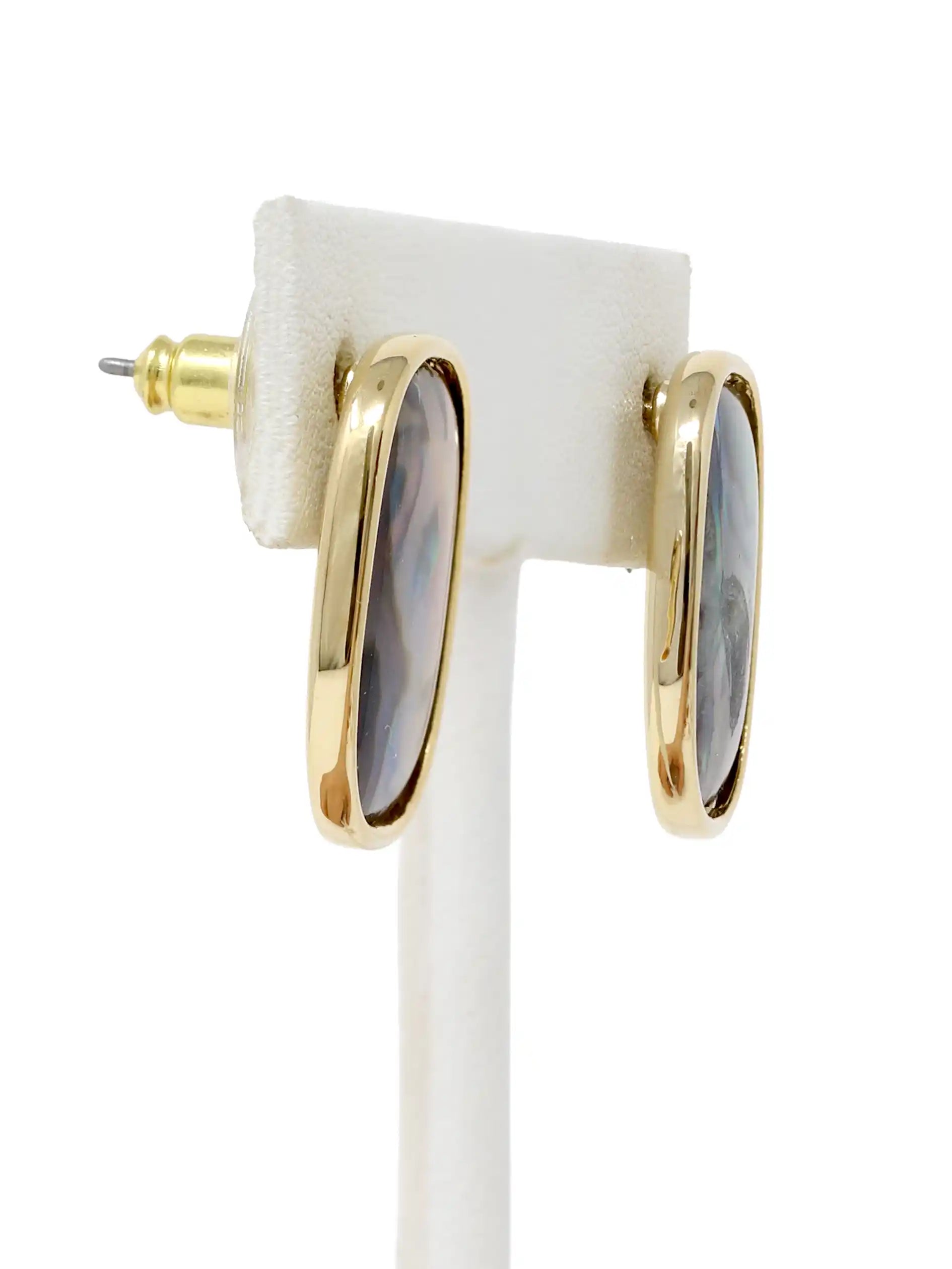 Gold hoop earrings with gray stones on a white stand