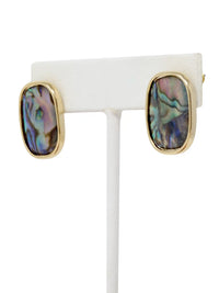 Pair of gold earrings with multicolored stone on a white stand