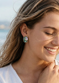 Woman wearing floral earrings with a blurred background