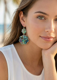 Woman wearing colorful floral earrings with a blurred natural background