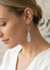 Silver leaf drop dangle earrings with textured circular links and detailed cutout leaf pendants.