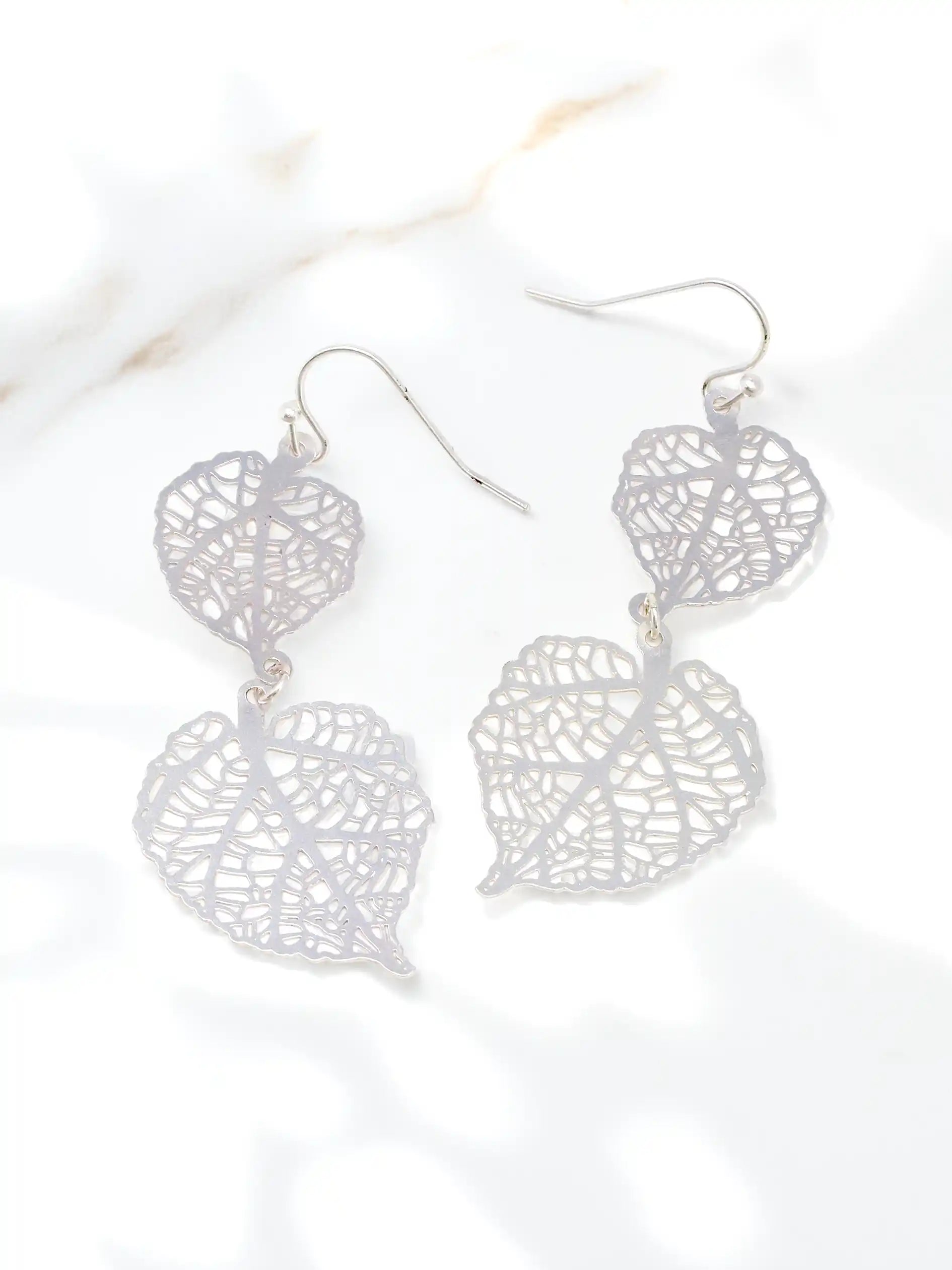 Silver leaf-shaped earrings on a white background