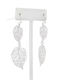 Silver leaf-shaped earrings on a white stand against a white background