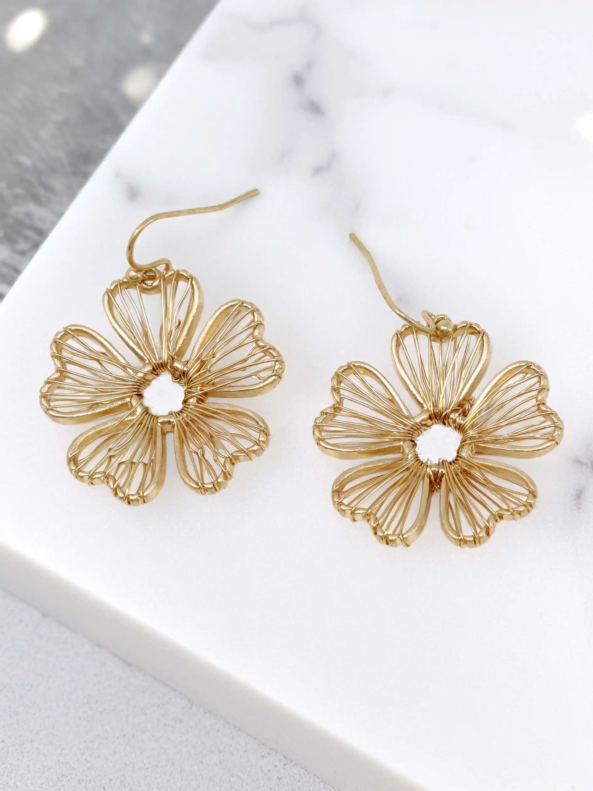 Gold wire flower drop earrings with open petal design and hook closure, featuring delicate floral filigree style in a lightweight gold-tone finish.