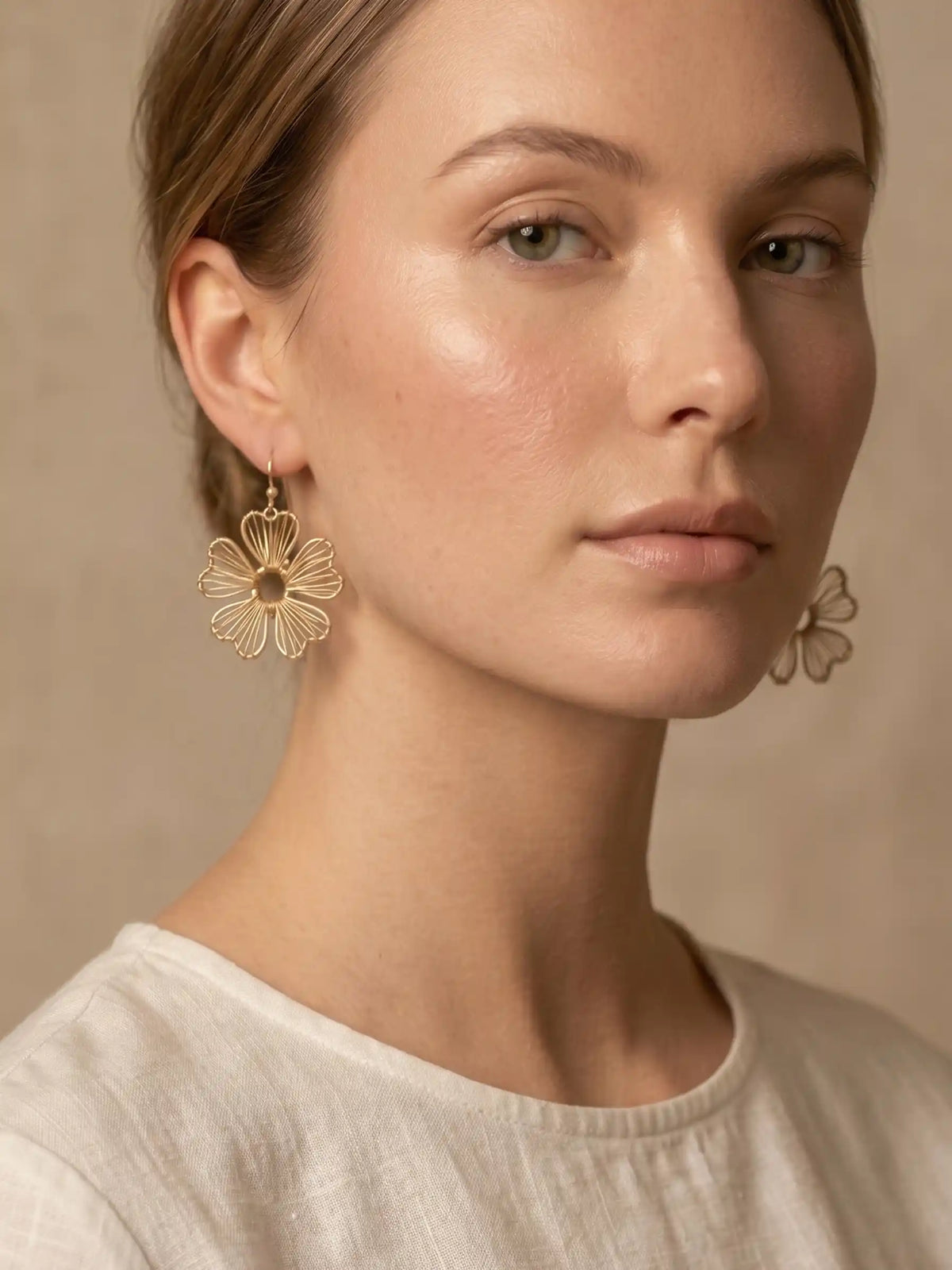 Gold wire flower drop earrings with open petal design and hook closure, featuring delicate floral filigree style in a lightweight gold-tone finish.