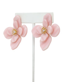 Pink flower-shaped earrings with gold centers on a white stand.