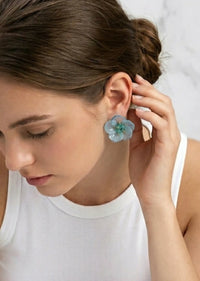 Woman wearing a floral earring with a white background