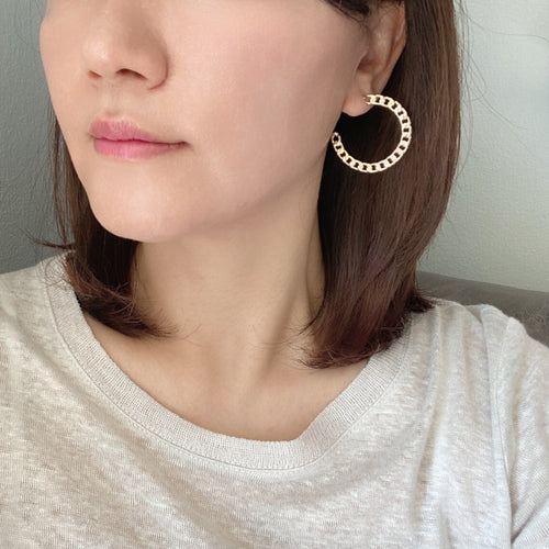 A pair of cuban chain textured hoop earrings made of gold filled.