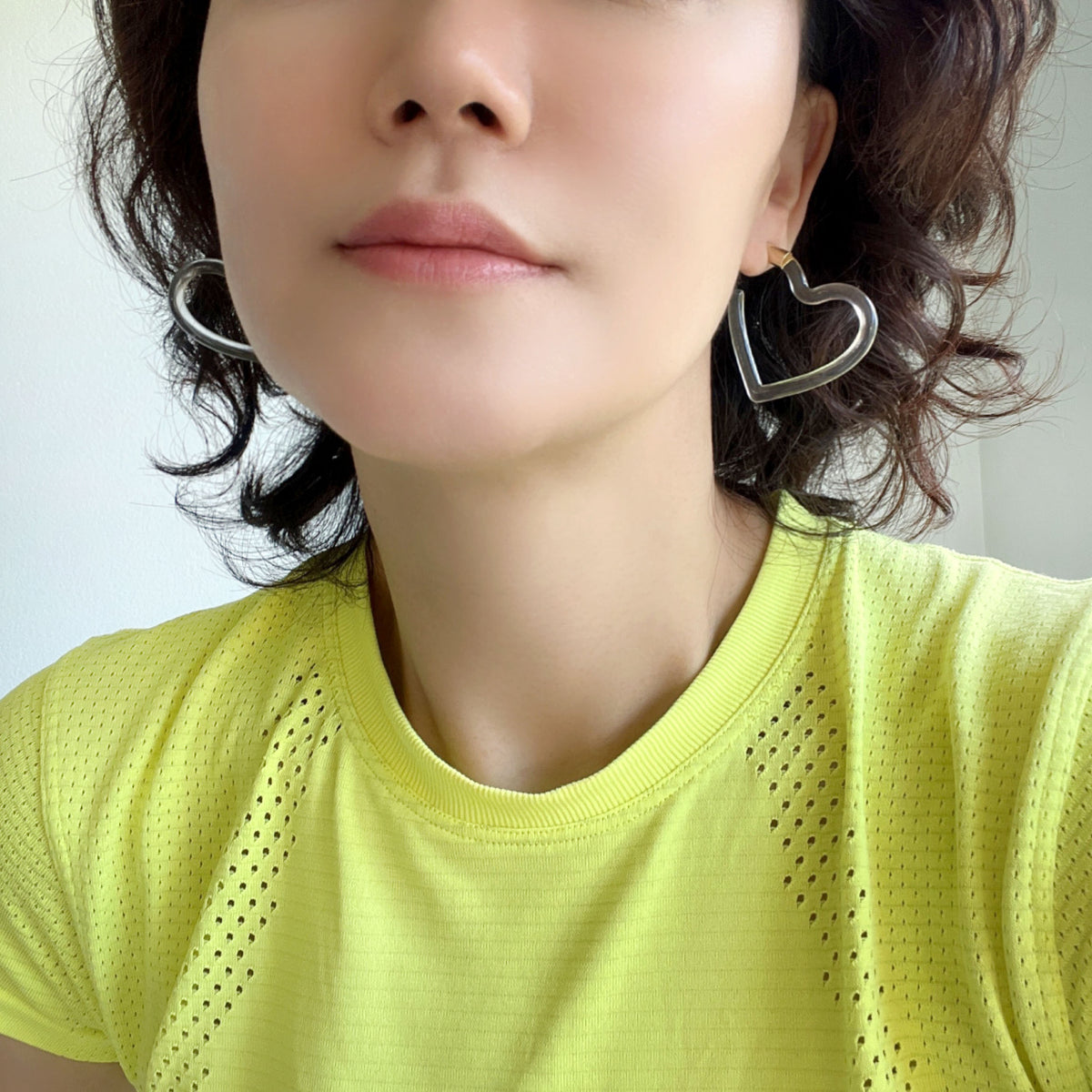 A pari of heart shaped hoop earrings feature a sleek and polished transparent resin that catches the light beautifully.
