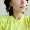 A pari of heart shaped hoop earrings feature a sleek and polished transparent resin that catches the light beautifully.