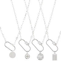 Four silver chain necklaces with capsule-shaped pendants and different dangling charms, including a smiley face, a textured round medallion, a blank round disc, and a rectangular block, displayed on a white background.