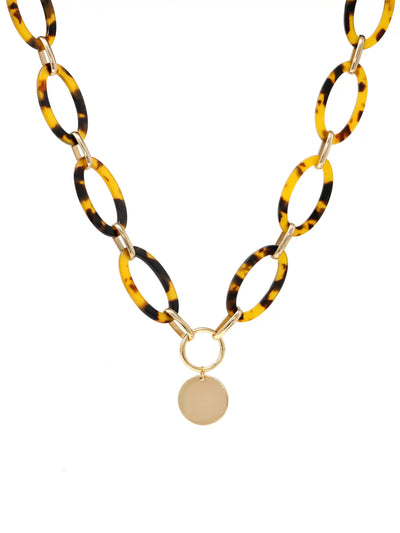 A statement necklace against a white background, featuring large, oval tortoiseshell resin links connected by gold-toned metal and a central, polished gold-toned circular pendant.