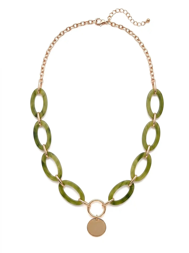 A statement necklace against a white background, featuring large, oval olive green colored resin links connected by gold-toned metal and a central, polished gold-toned circular pendant.