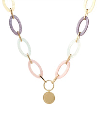 A statement necklace against a white background, featuring large, oval pastel multi colored resin links connected by gold-toned metal and a central, polished gold-toned circular pendant.
