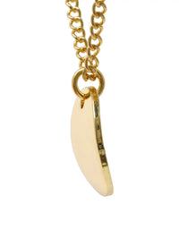 A gold chain necklace with a small, flat, crescent-shaped cream or off-white pendant, shown against a plain white background.