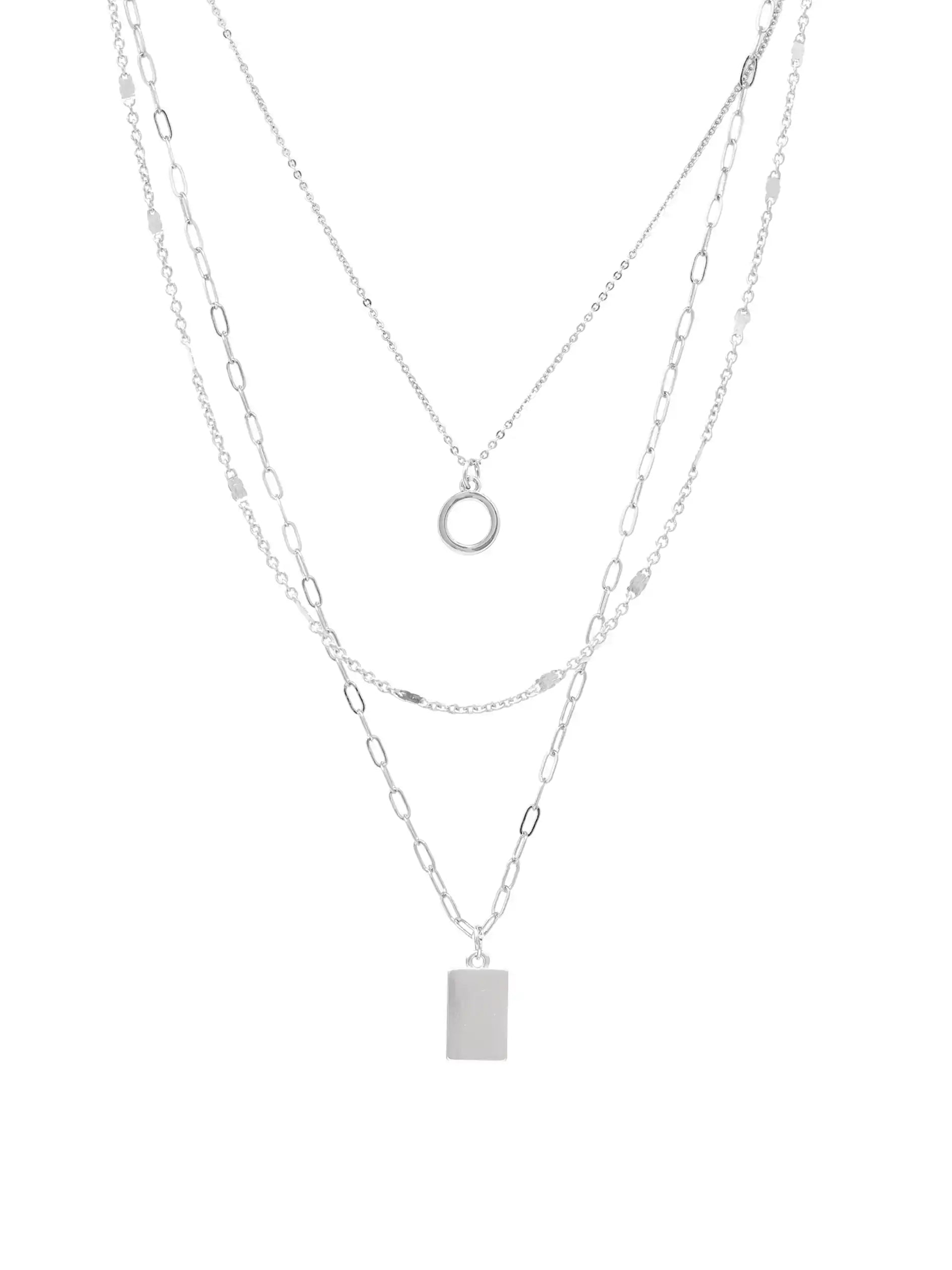 A layered silver necklace set featuring three delicate chains: a fine chain with a small circular ring pendant, a chain with a rectangular bar pendant, and a chain with elongated oval links, all on a plain white background.