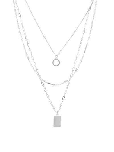 A layered silver necklace set featuring three delicate chains: a fine chain with a small circular ring pendant, a chain with a rectangular bar pendant, and a chain with elongated oval links, all on a plain white background.