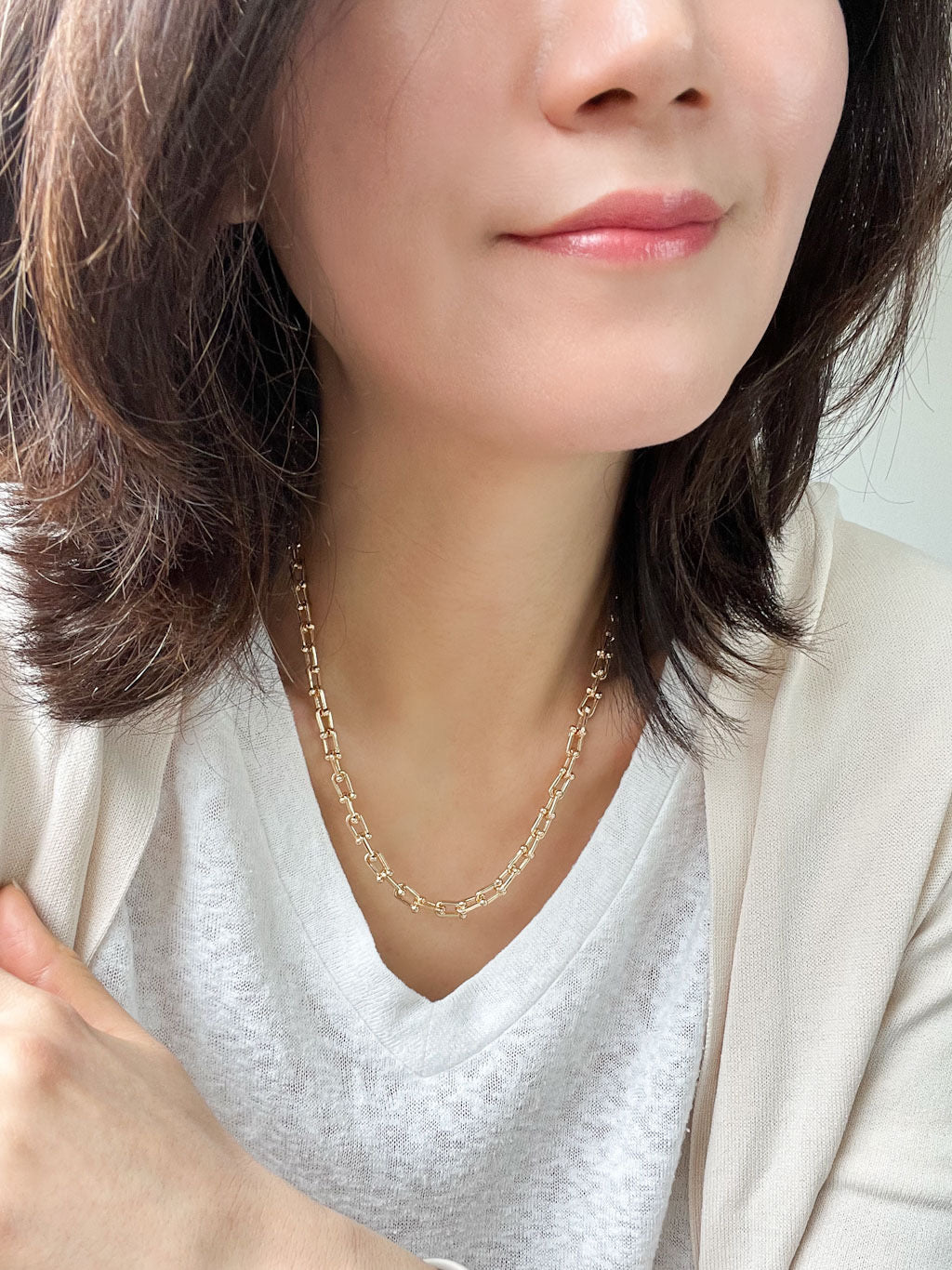 A bold gold link chain necklace with geometric links and polished bead connectors.