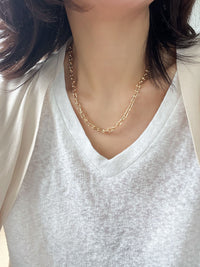 A bold gold link chain necklace with geometric links and polished bead connectors.