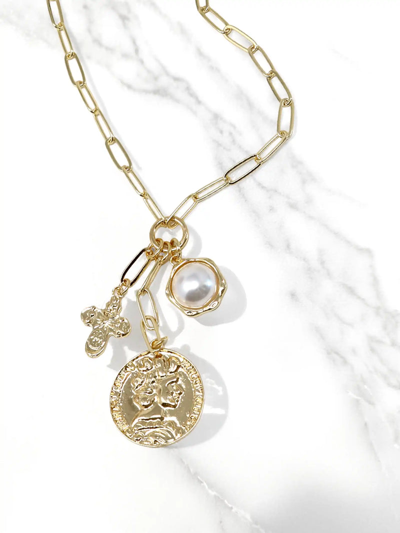 Gold necklace with various charms on a white background