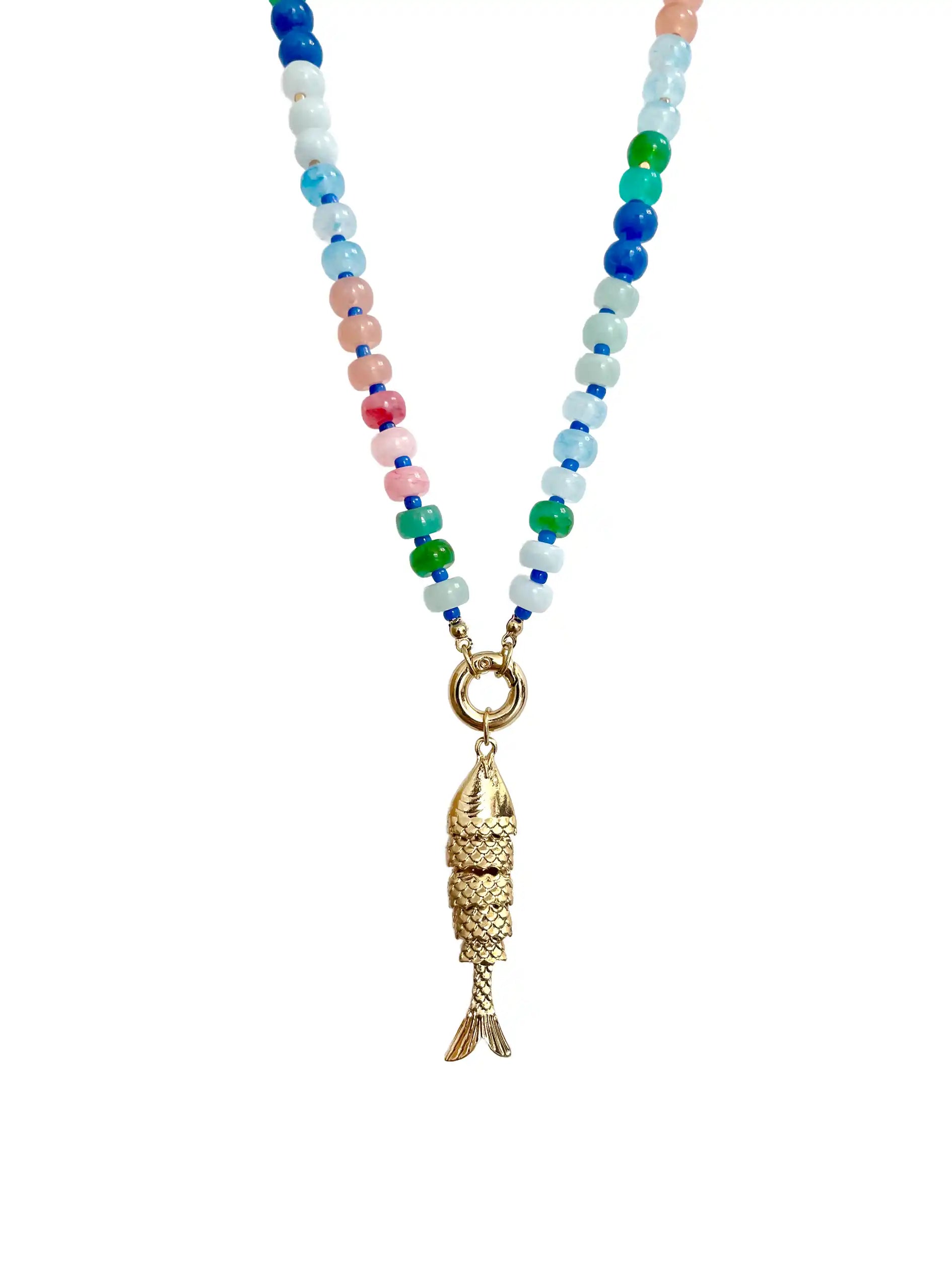 A beaded necklace featuring a gold fish pendant hanging from a strand of small, multicolored beads in shades of blue, green, pink, and white, set against a plain white background.