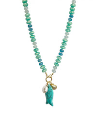 Turquoise and blue beaded statement necklace featuring glossy rondelle beads in aqua, teal, and deep blue tones. The necklace is accented with a large turquoise fish charm, a freshwater pearl, and a gold-tone scallop shell charm