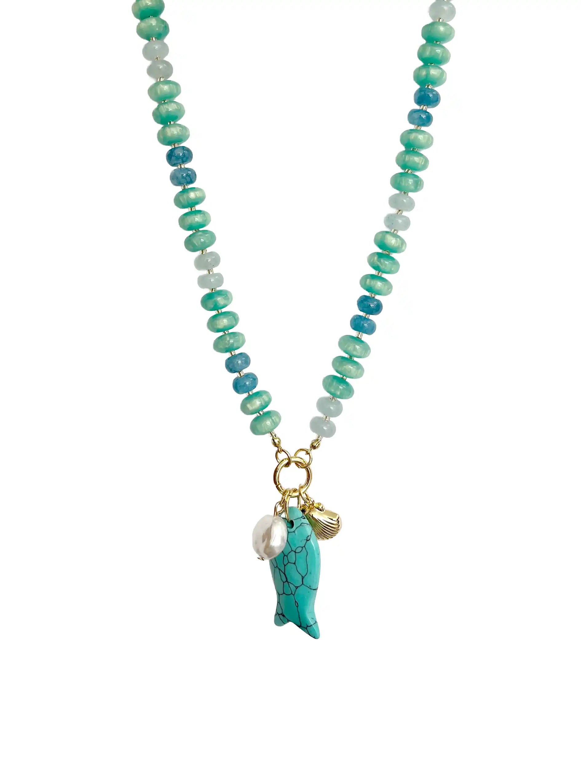 Turquoise and blue beaded statement necklace featuring glossy rondelle beads in aqua, teal, and deep blue tones. The necklace is accented with a large turquoise fish charm, a freshwater pearl, and a gold-tone scallop shell charm