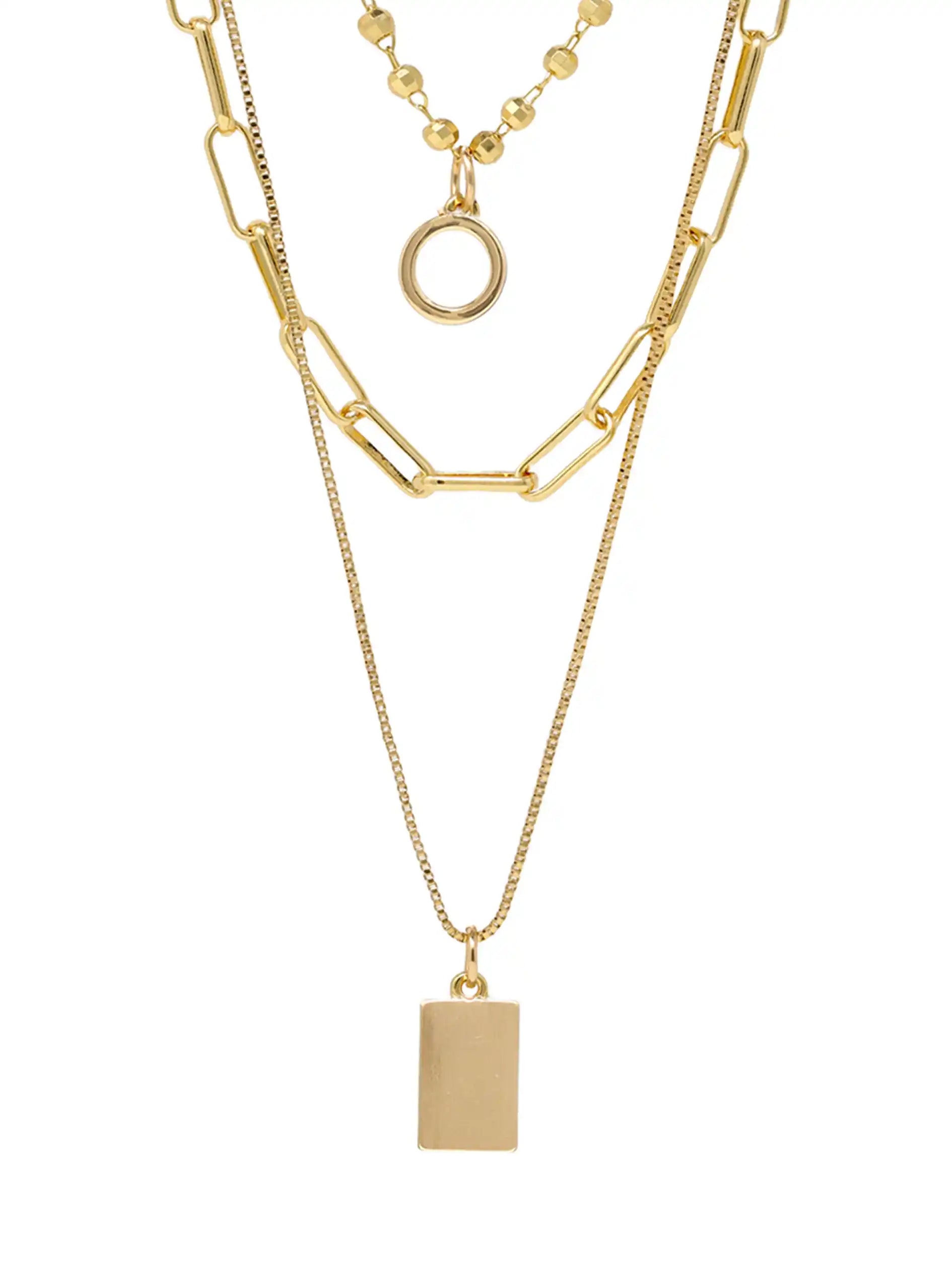 A gold-toned three-layer necklace against a plain white background. The top layer features a short beaded chain with a simple circular ring pendant. The middle layer is a wider chain with elongated oval links. The bottom, longest layer is a fine chain with a solid rectangular bar pendant.