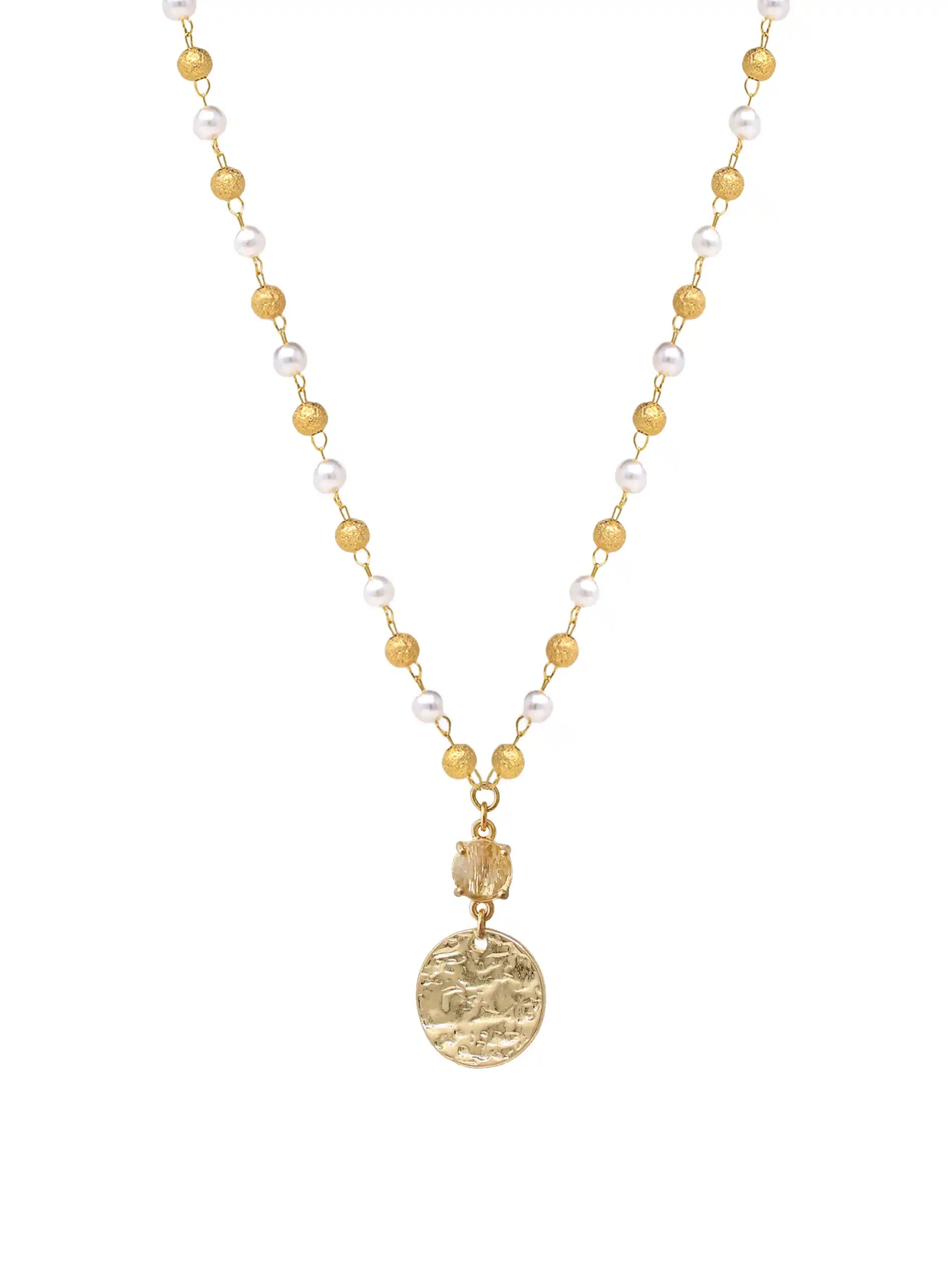 A gold-tone beaded necklace featuring small round gold beads, white pearl-like beads, and a textured gold coin pendant, shown against a plain white background.