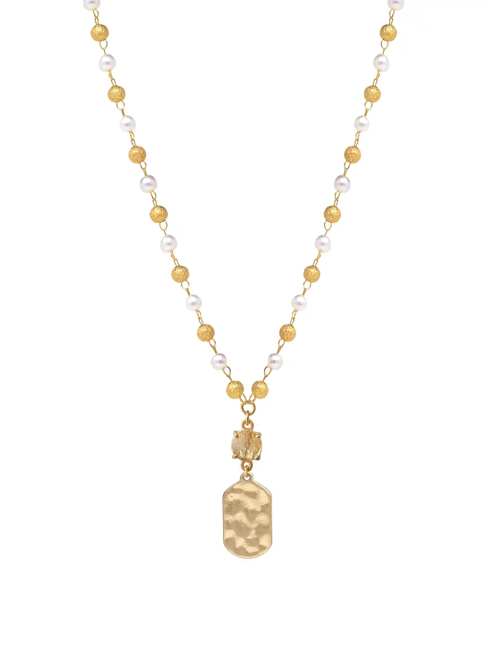A gold-tone necklace featuring a beaded chain with alternating white pearls and gold beads, ending in a hammered gold pendant, shown on a plain white background.
