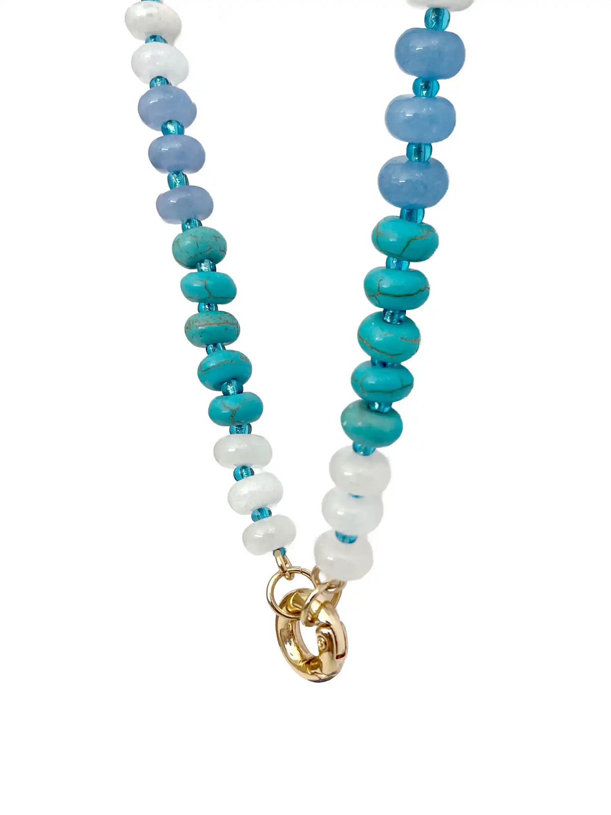 Blue beaded statement necklace with mixed white, turquoise, and dark blue beads, gold-tone clasp, and textured round coin pendant on a white background.