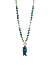A beaded necklace featuring green and blue gradient round beads with a polished dark moss green agate fish-shaped pendant, suspended from a gold ring on a white background.