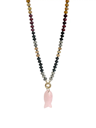 A beaded necklace featuring a central pink rose quartz fish-shaped pendant, suspended from a multi-colored strand of faceted beads in black, gray, tan, burgundy, and gold-toned tones, set against a plain white background.