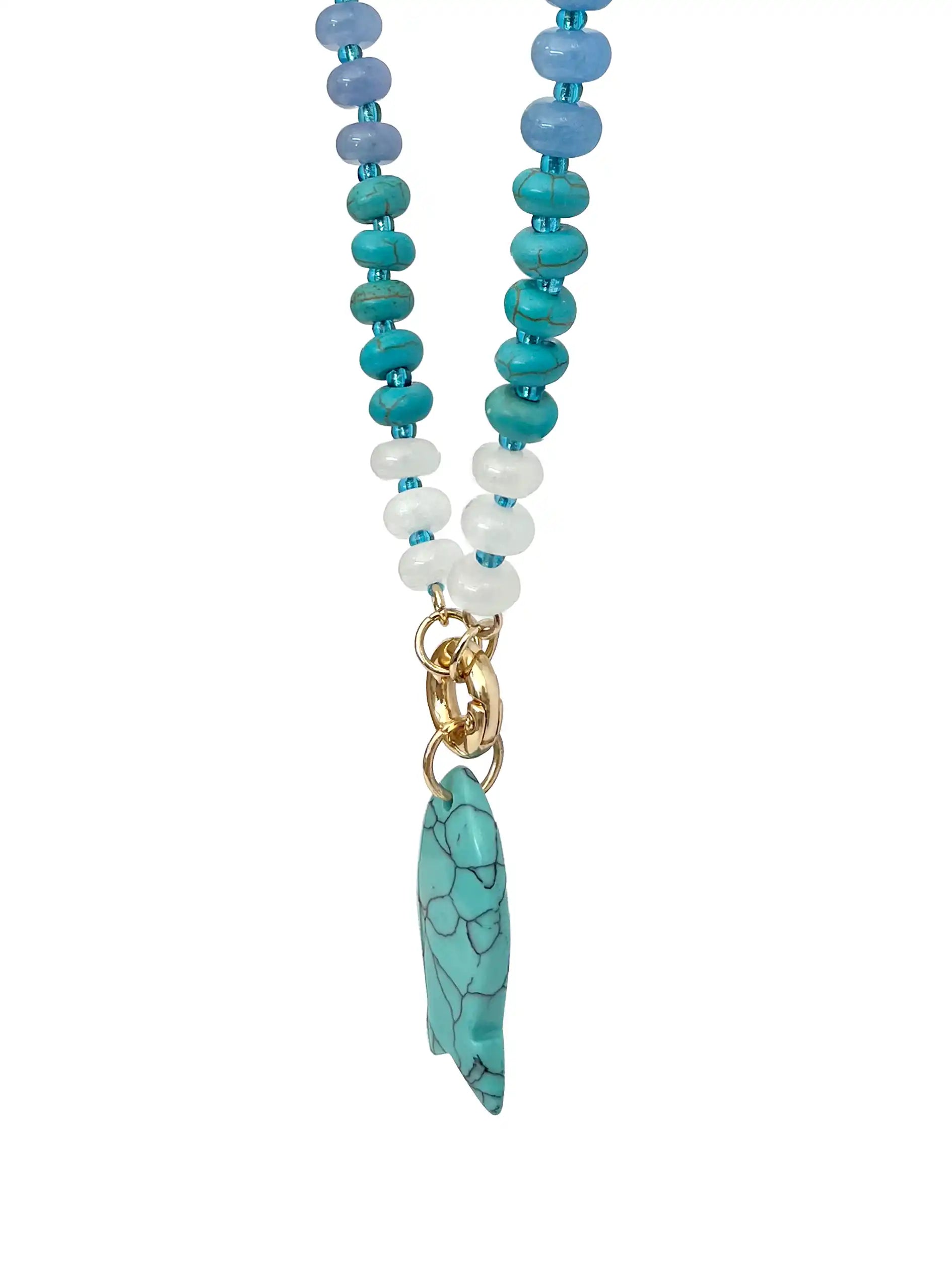 A beaded necklace featuring turquoise, light blue, and white beads with a gold-tone clasp and a turquoise stone pendant, shown against a plain white background.
