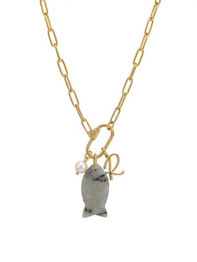 A gold paperclip chain necklace featuring a front-facing carabiner clasp that holds three distinct charms: a small round pearl, a gold script initial R, and a carved gray labradorite fish pendant.