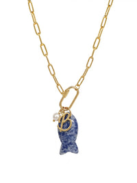 A gold paperclip chain necklace featuring a front-facing carabiner clasp that holds three distinct charms: a small round pearl, a gold script initial B, and a carved blue sodalite fish pendant.