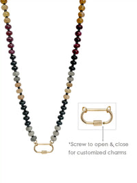 A semi-precious stone beaded necklace with dark gray, black, light gray, tan, and deep red beads, featuring a gold-toned carabiner. An inset diagram on the right shows a close-up of the clasp with text reading '*Screw to open & close for customized charms'.