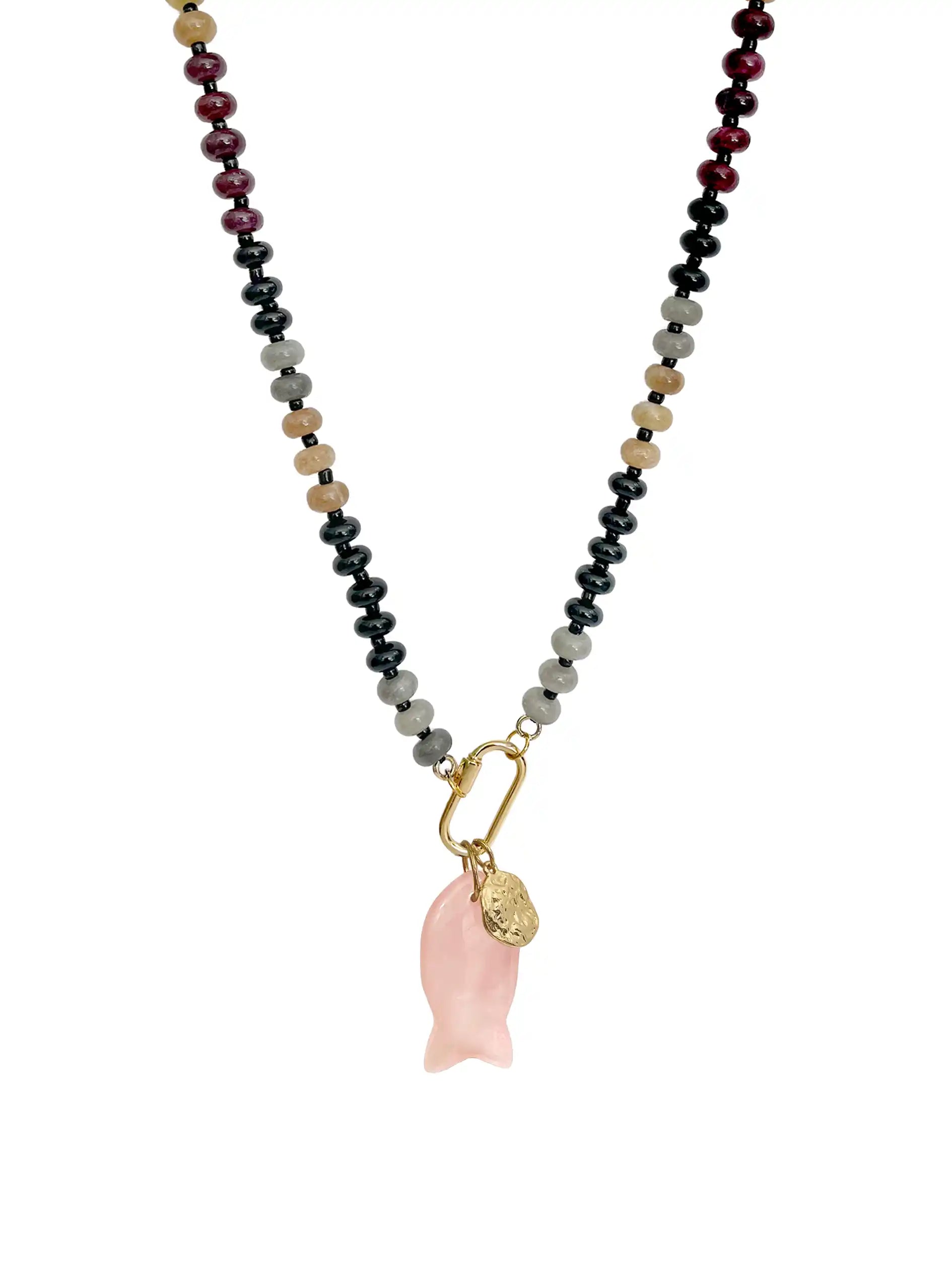 A beaded necklace featuring a strand of beads in black, gray, tan, and deep red, with a gold carabiner holding a pink rose quartz fish-shaped pendant and a small gold textured coin, shown on a plain white background.