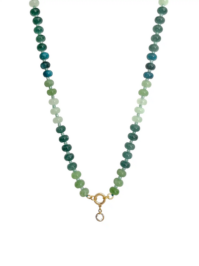 A beaded necklace featuring three vertical strands of round beads in shades of green, teal, and white, finished with a gold ring and a small hanging charm, shown against a plain white background.