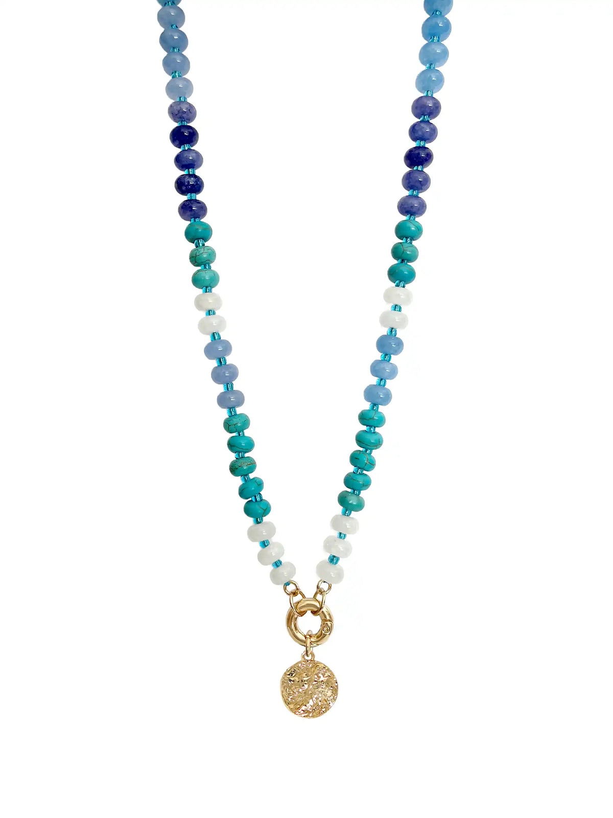 Blue beaded statement necklace with mixed white, turquoise, and dark blue beads, gold-tone clasp, and textured round coin pendant on a white background.