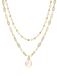 A double-layered gold necklace featuring a paperclip chain with a round pale pink stone pendant and a beaded chain with white pearls, shown on a plain white background.