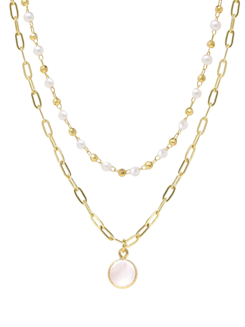 A double-layered gold necklace featuring a paperclip chain with a round pale pink stone pendant and a beaded chain with white pearls, shown on a plain white background.