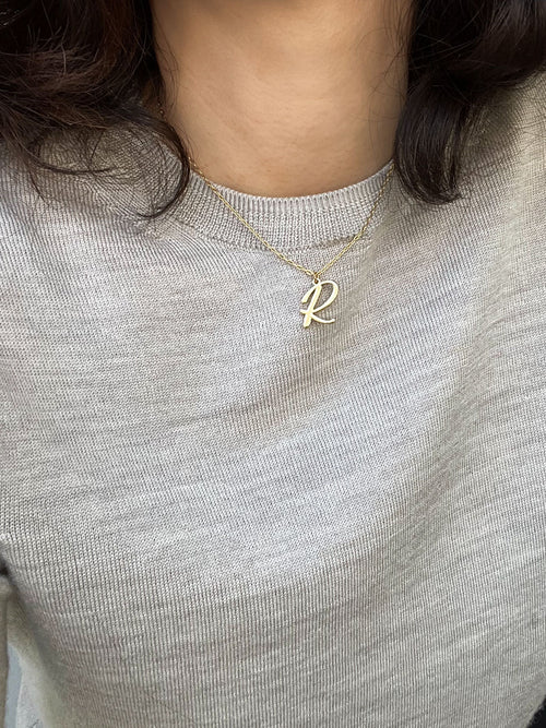 Script initial letter charm necklace dangled in a gold-filled paperclip chain.