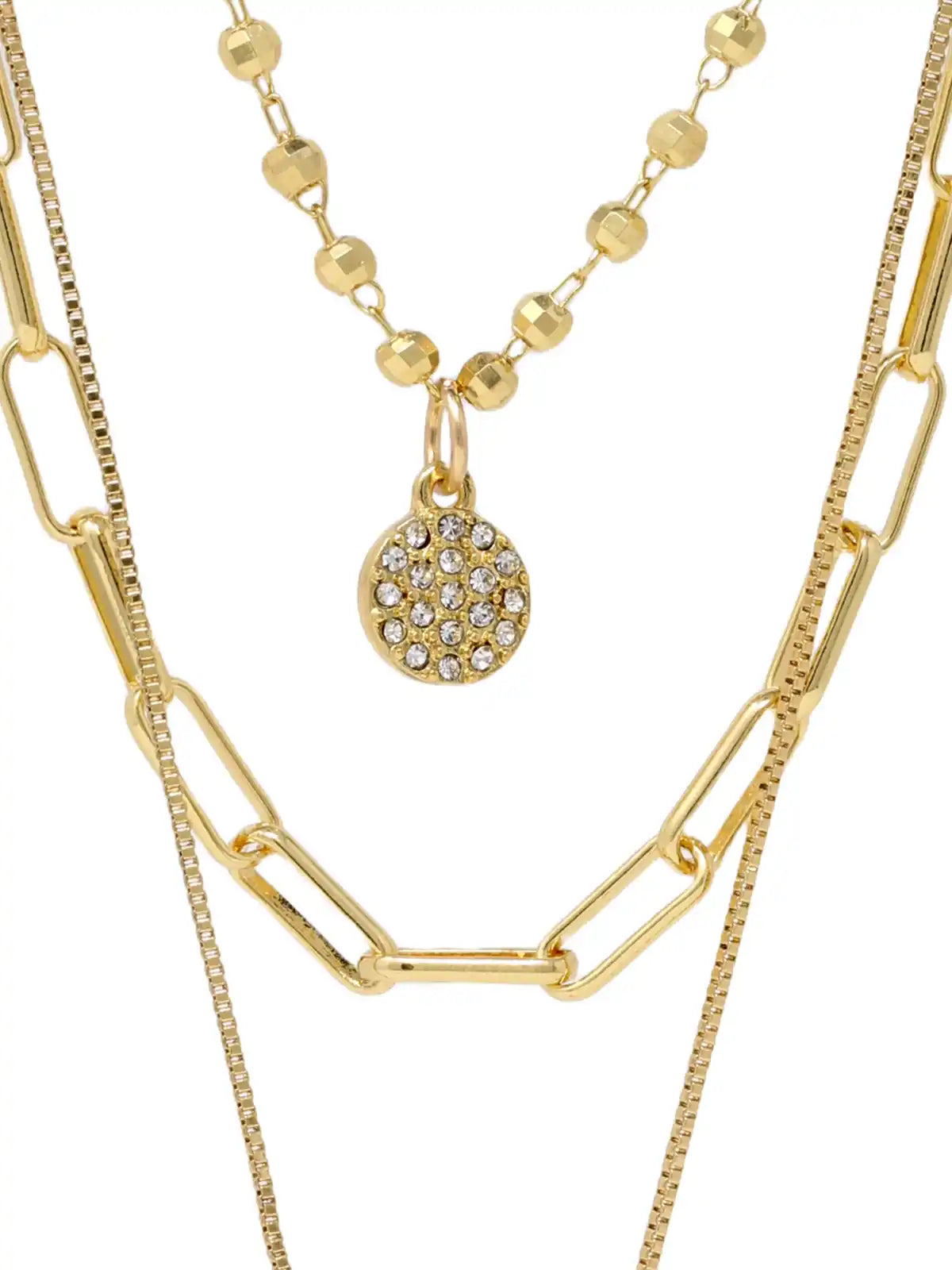 A layered gold necklace set featuring a paperclip chain, a beaded chain with a round pavé crystal pendant, and a fine chain, shown against a plain white background.