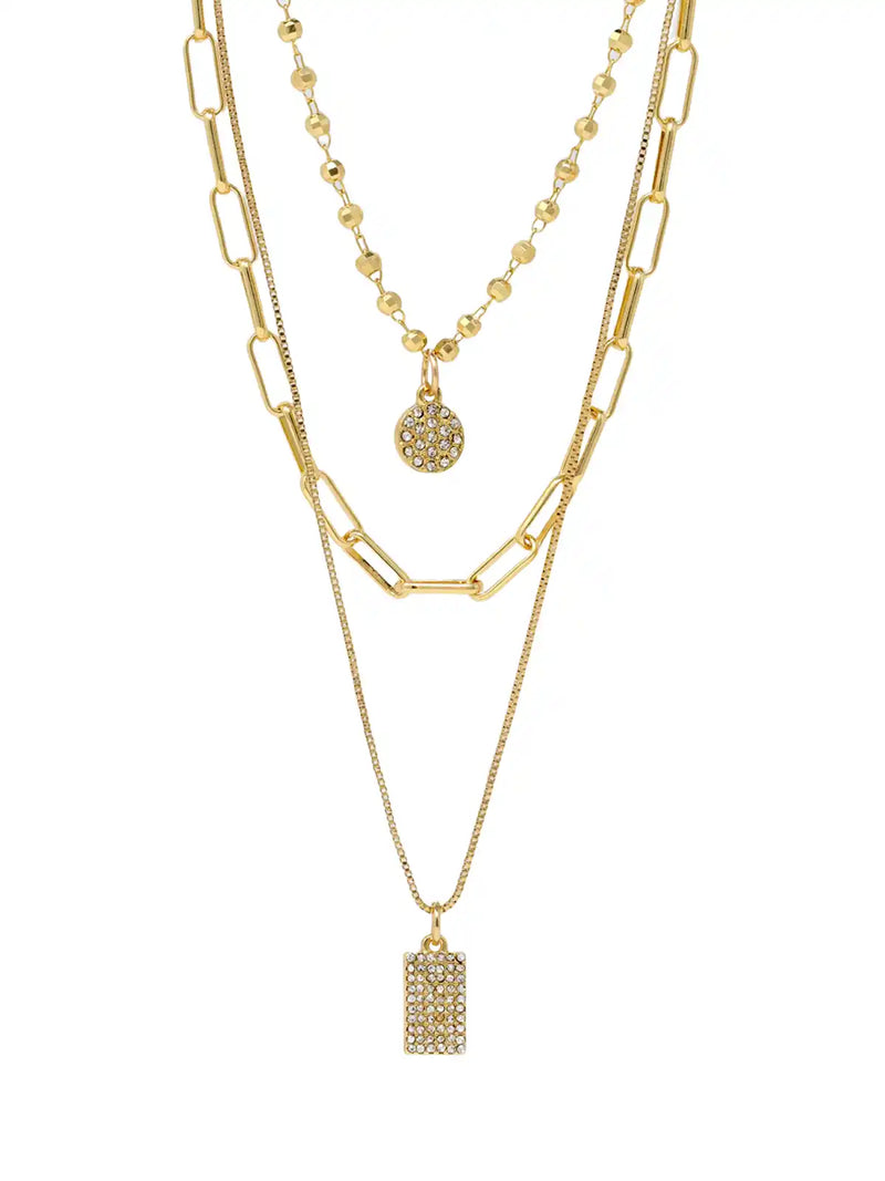 A gold layered necklace set featuring three distinct chains: a chunky paperclip chain, a delicate beaded chain with a round pavé pendant, and a fine chain with a rectangular pavé pendant, all displayed on a clean white background.