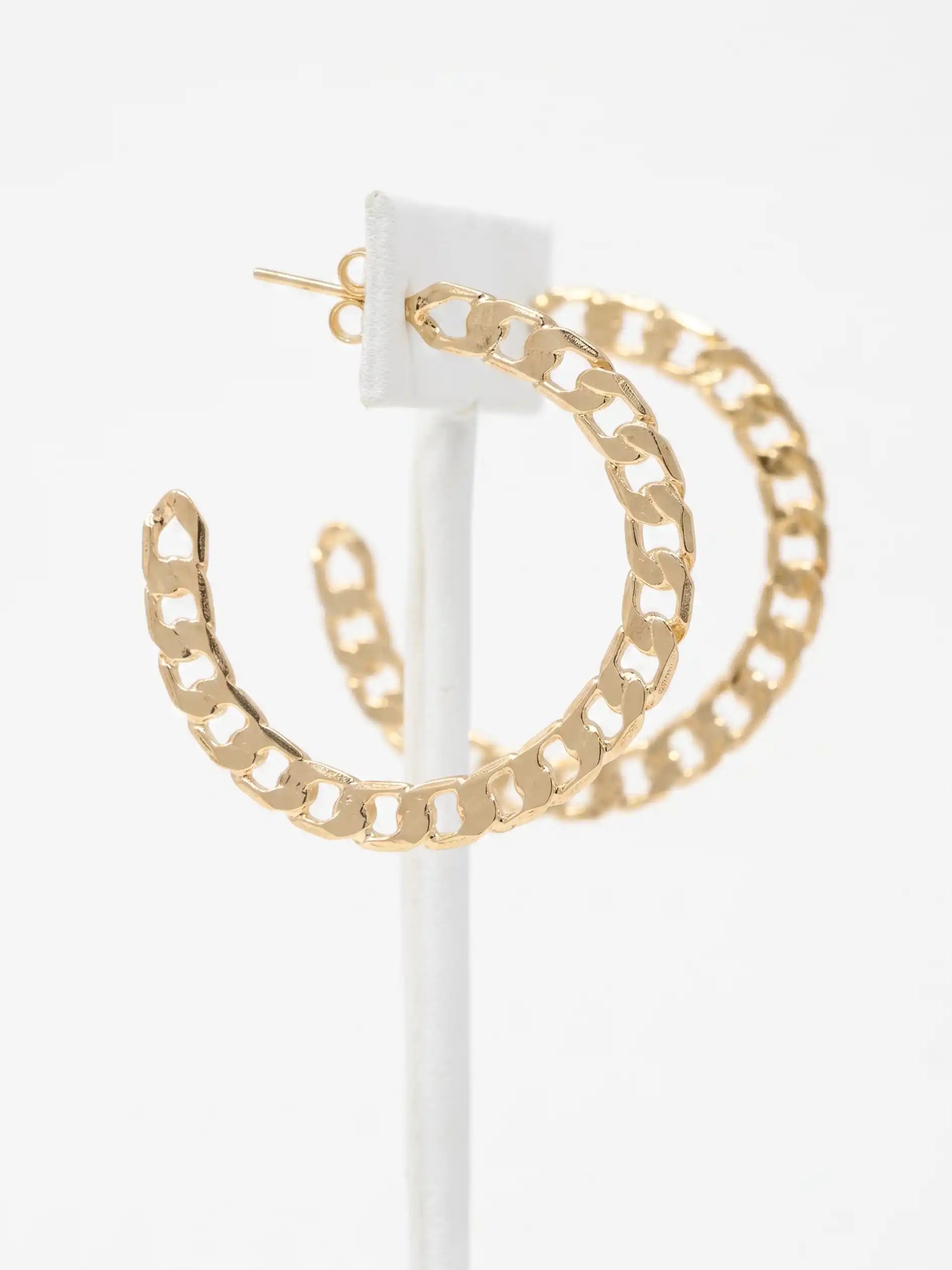 Gold-tone chain-link hoop earrings displayed on a white jewelry stand against a clean white background.