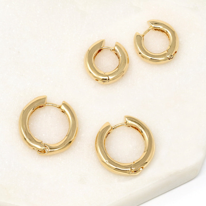 A pair of bold simple hoop huggie earrings made of gold filled.