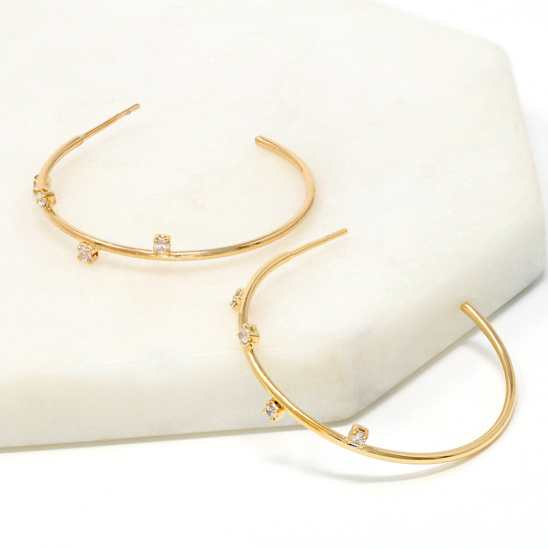 A pair of crystal accented delicate hoop earrings made of gold filled.